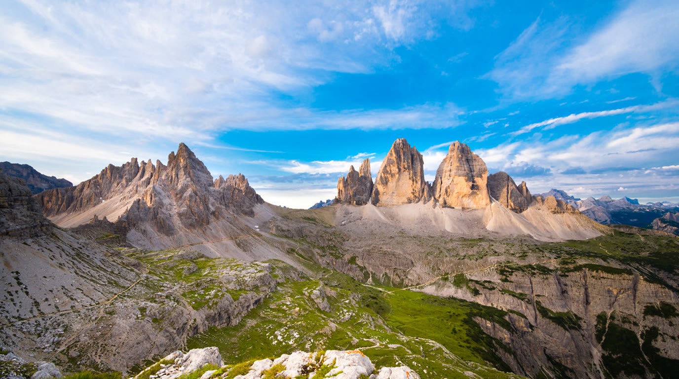 Skalní věže Dolomit nad zeleným horským údolím za letního rána