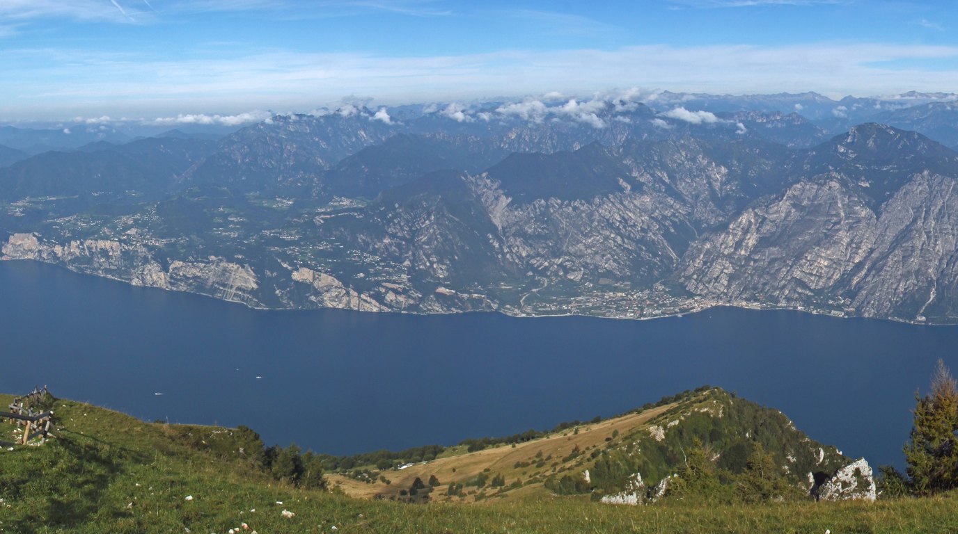 Severní břeh jezera Lago di Garda se skalními stěnami spadajícími k hladině a městečkem u vody