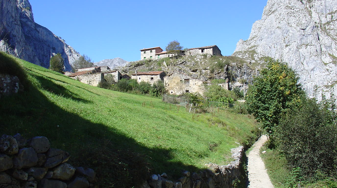 Vápencové štíty národního parku Picos de Europa nad zelenými svahy v severním Španělsku