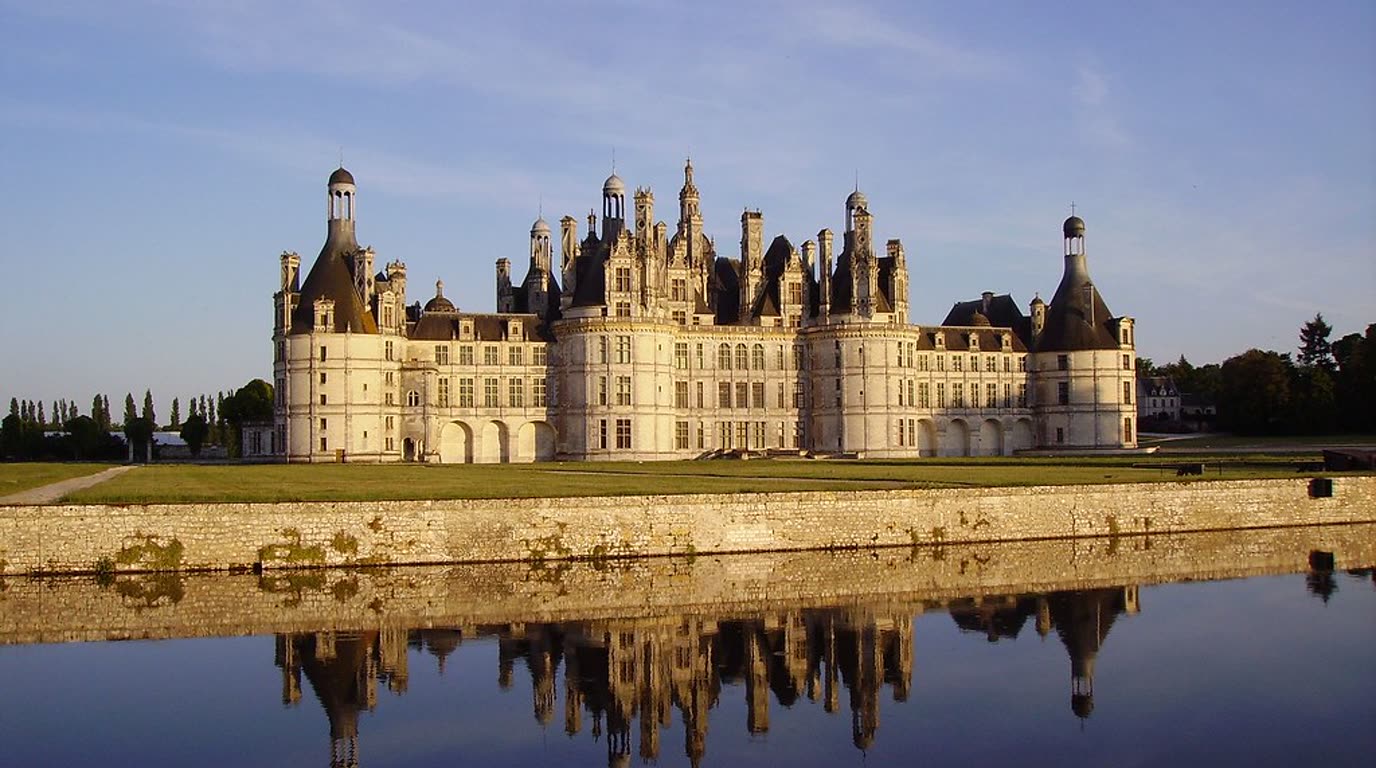 Renesanční zámek Chambord se změtí věžiček a komínů na střeše, obklopený parkem v údolí Loiry