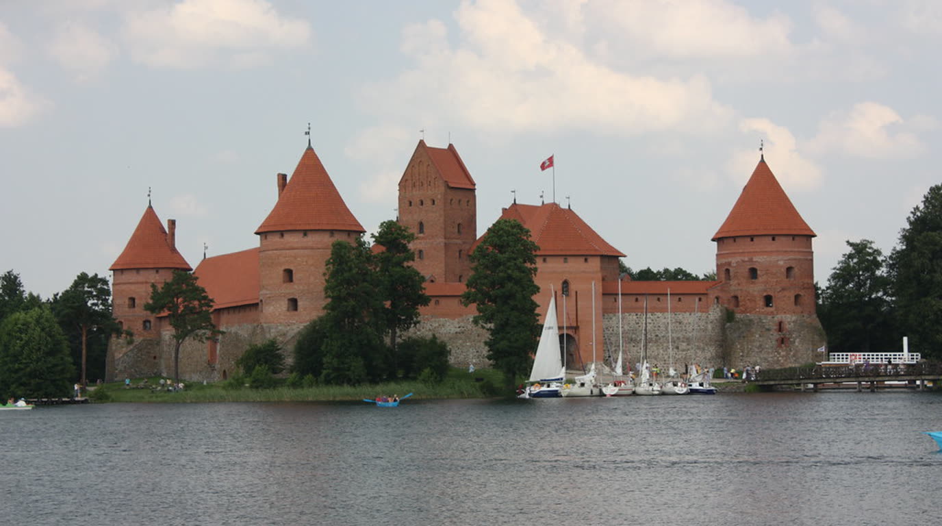 The brick island castle in Trakai, Lithuania, in the middle of Lake Galvė, linked to the shore by a wooden footbridge